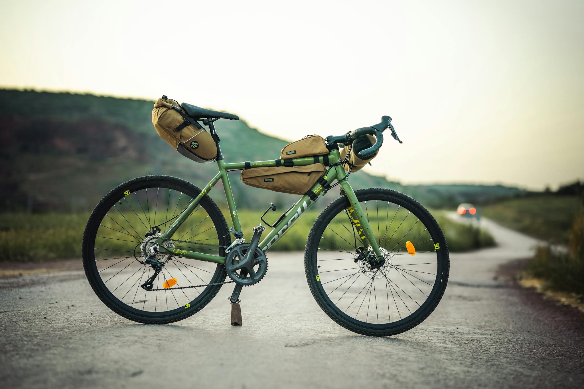A fully equipped adventure bicycle stands on a scenic rural road, perfect for exploration.